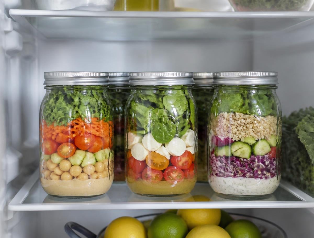 Vários potes de salada organizados dentro da geladeira